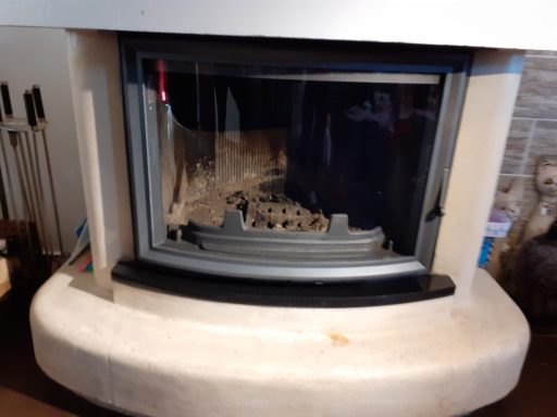 Cheminée moderne encastrée avec un cadre en métal et un foyer ouvert.